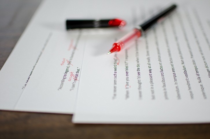 Red pen editing a manuscript / Getty Images