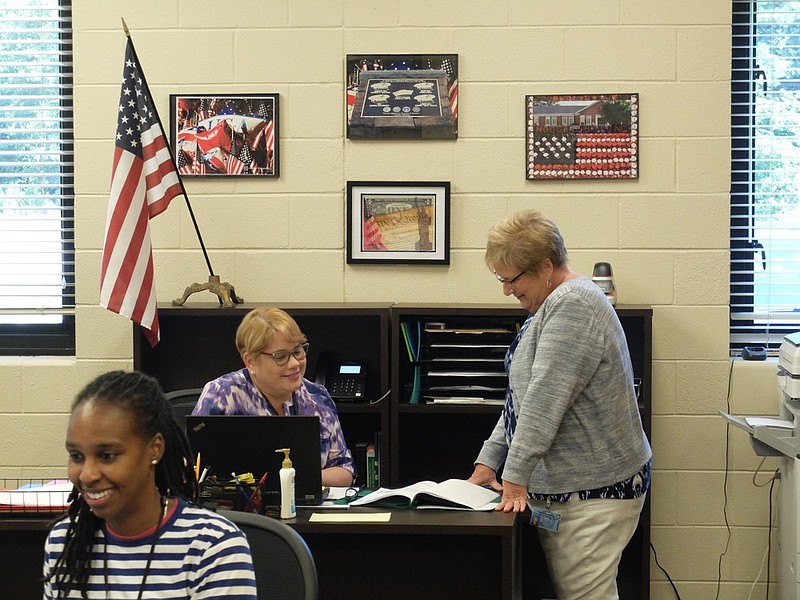 Staff photo by Tim Barber /
Office personnel at East Brainerd Elementary School with a display of framed prints showing patriotic themes, and an American flag inside the school front office. From left are, Telicia Howell, clerical, Marie Rivera, interpreter, and Kay Jetton, school secretary.