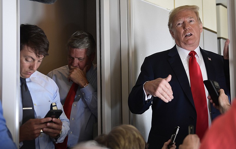 White House Deputy Press Secretary Hogan Gidley, left, and White House Deputy Chief of Staff for Communications, Bill Shine, center, listen as President Donald Trump talks to reporters while in flight from Billings, Mont., to Fargo, N.D., Friday, Sept. 7, 2018. (AP Photo/Susan Walsh)