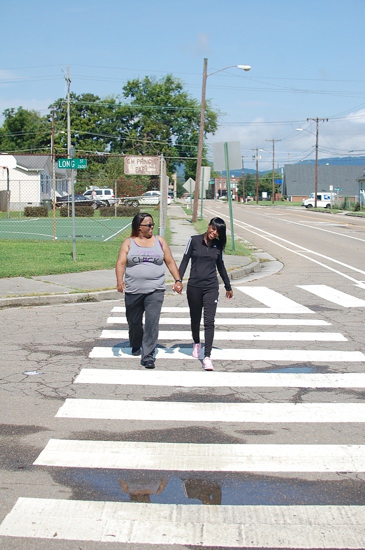 Lupus patients Tina Reid and Kenyetta Bray walk together in South Chattanooga. They are among several women organizing the Lapse for Lupus walk Sept. 22.(Contributed Photo by Bob James IV)