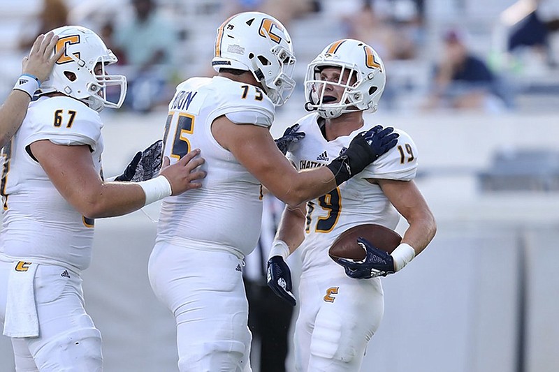 UTC wide receiver Bryce Nunnelly, right, celebrates with offensive linemen Harrison Moon, center, and Noah Ramsey after scoring a touchdown against The Citadel on Saturday in Charleston, S.C.