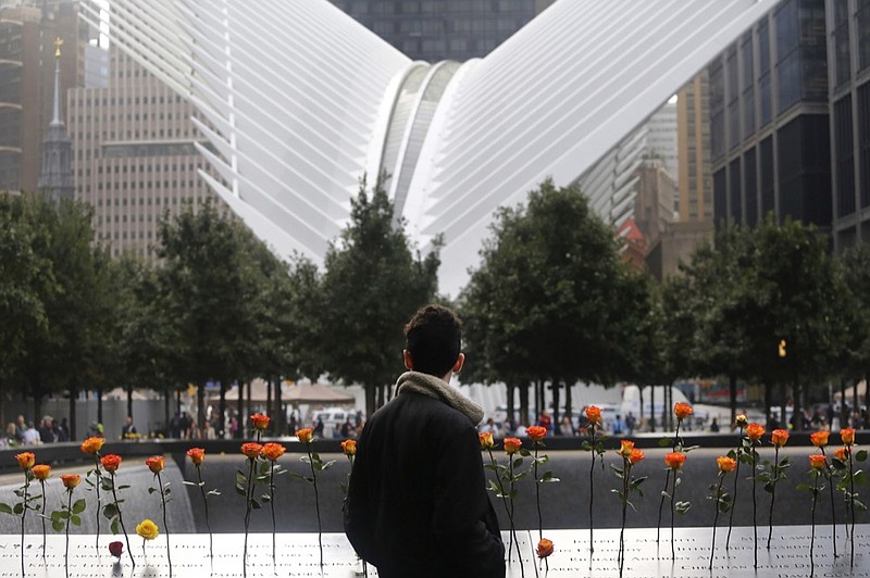 A man looks at the North Pool at the World Trade Center during a ceremony marking the 17th anniversary of the terrorist attacks on the United States. Tuesday, Sept. 11, 2018, in New York. In the background is the World Trade Center Transportation Hub. (AP Photo/Mark Lennihan)

