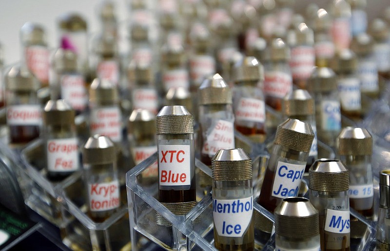 This Dec. 4, 2013, file photo shows vials of flavored liquid at a store selling electronic cigarettes and related items in Los Angeles.