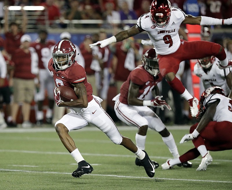 Alabama wide receiver DeVonta Smith, left, runs past Louisville linebacker C.J. Avery during the season opener in Orlando, Fla. Smith leads Alabama with 176 receiving yards through two games this season.