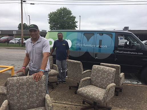 Chattanooga's Office Coordinators Inc. employees, Charles Bradford, in front, and William Middlebrooks, deliver furniture to Orchard Knob Middle School.