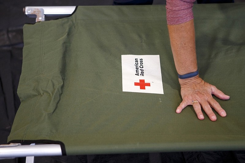 Staff photo by C.B. Schmelter / 
April Martin, with American Red Cross Disaster Cycle Services, preps a cot in the gym at the Brainerd Youth and Family Development Center on Thursday, Sept. 13, 2018 in Chattanooga, Tenn. The Hamilton County Office of Emergency Management, American Red Cross and other organizations are joining to open and operate a shelter at the Brainerd Youth & Family Development Center for coastal residents fleeing Hurricane Florence, according to a news release.