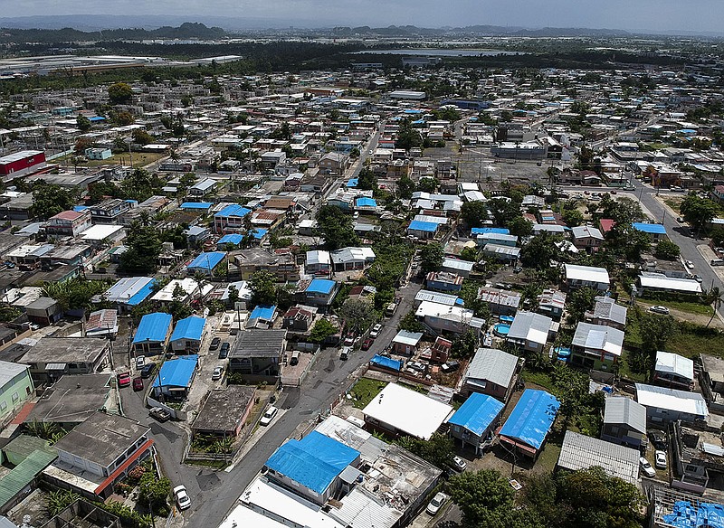 This year-after photo of San Juan, Puerto Rico, illustrates that thousands of people across the island are still living in damaged homes, protected by blue plastic tarps, after Hurricane Maria devastated the island in 2017. (AP Photo/Dennis M. Rivera)