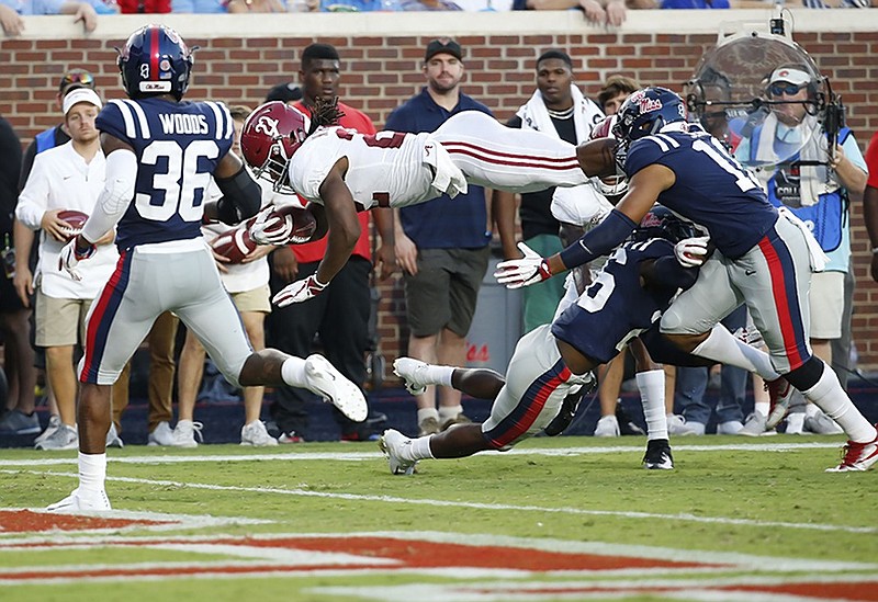 Alabama running back Najee Harris leaps over Ole Miss defensive back Jalen Julius and into the end zone for a 10-yard touchdown run during Saturday's game in Oxford, Miss.