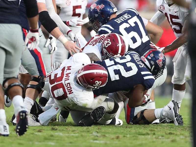 
Alabama linebackers Mack Wilson (30) and Anfernee Jennings (33) bring down Ole Miss running back Scottie Phillips during Saturday night's 62-7 rout by the Crimson Tide. / Contributed photo by Kent Gidley/Alabama athletics
