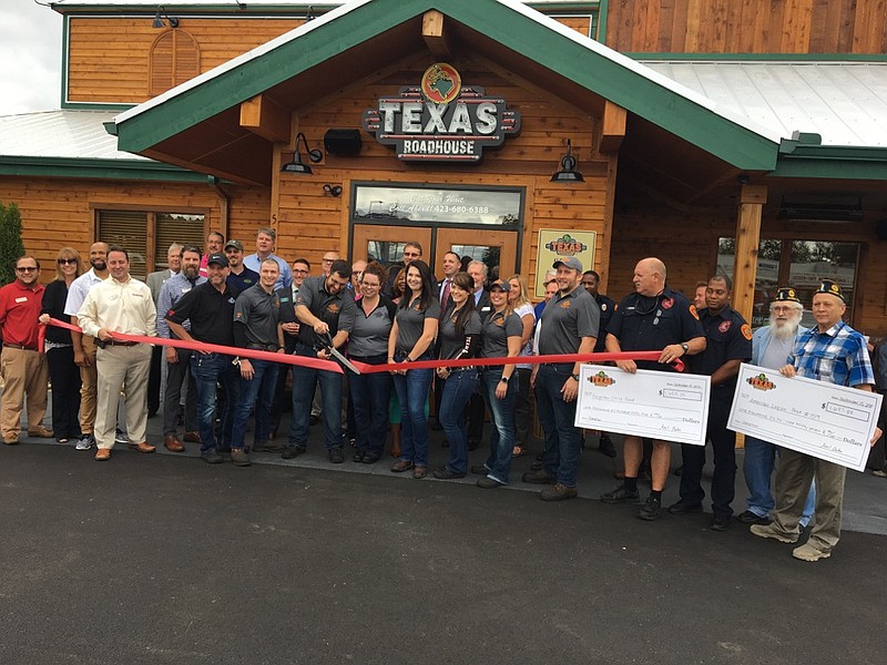 Photo by Dave Flessner / Axel Balow, managing partner for the Texas Roadhouse in Hixson, cuts the ribbon to open the restaurant on Highway 153 Monday.