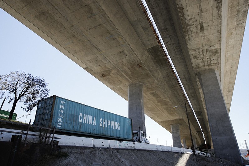 FILE - In this July 2, 2018, file photo, a truck carrying a cargo container drives under the Gerald Desmond Bridge under construction in Long Beach, Calif. China on Tuesday, Sept. 18, announced a tariff hike on $60 billion of U.S. products in response to President Donald Trump's latest duty increase in a dispute over Beijing's technology policy. (AP Photo/Jae C. Hong, File)