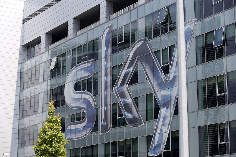 FILE - This Friday, July 25, 2014, file photo shows a view of the headquarters of the Italian Sky television broadcaster in Milan, Italy.  British regulators say that the corporate battle between 21st Century Fox and Comcast to take over broadcaster Sky will be settled by auction, commencing at 5 p.m. on Sept. 21 and ending on the evening of Sept. 22, 2018. (AP Photo/Luca Bruno, File)