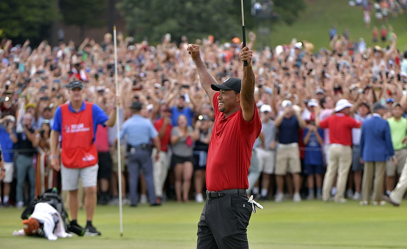 Tiger Woods celebrates on the 18th green Sunday at East Lake Golf Club in Atlanta after winning the Tour Championship. Woods, whose career was derailed by back surgeries, completed his comeback with a two-stroke victory, his first win since August 2013 at the Bridgestone Invitational.