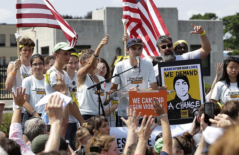 In this Sunday, Aug. 26, 2018 file photo, David Hogg, center, a survivor of the school shooting at Marjory Stoneman Douglas High School, in Parkland, Fla., addresses a rally in front of the headquarters of gun manufacturer Smith & Wesson in Springfield, Mass. The rally was held at the conclusion of a 50-mile march meant to call for gun law reforms. (AP Photo/Steven Senne)