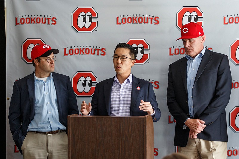 Chattanooga Lookouts co-owners Jason Freier, left, and John Woods, right, stand nearby as Cincinnati Reds Director of Player Development Eric Lee speaks during a news conference announcing the renewed partnership between the Lookouts and the Reds held at AT&T Stadium on Tuesday, Sept. 25, 2018, in Chattanooga, Tenn. The Lookouts where previously affiliated with the Reds for 21 seasons between 1988 and 2008.