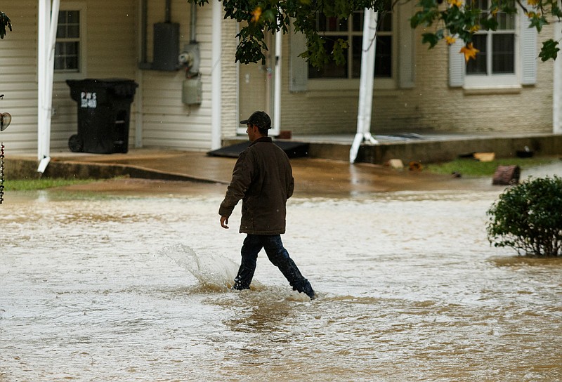 A man walks through floodwaters near homes on Dallas Hollow Road after heavy rainfall on Wednesday, Sept. 26, 2018, in Soddy-Daisy, Tenn. Heavy rains throughout the week caused flooding and closed schools across the region.