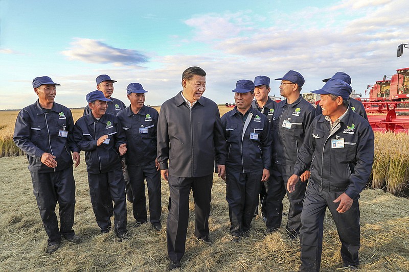 In this Sept. 25, 2018, photo released by China's Xinhua News Agency, Chinese President Xi Jinping, center, talks with workers at a farm in Jiansanjiang in northeastern China's Heilongjiang province. Xi was on an inspection tour of the region as China has slapped tariffs on U.S. agricultural imports and looked to increase farming self-sufficiency amid a growing trade war with the United States. (Xie Huanchi/Xinhua via AP)