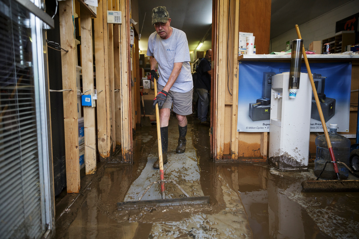 Gatekeepers Inc. owner Marty Kazmier mops mud out of his business one day after a deadly flash flood in the Depot Street area on Thursday, Sept. 27, 2018, in Soddy-Daisy, Tenn. Residents, volunteers and business owners returned Thursday following the flooding which killed one person Wednesday.