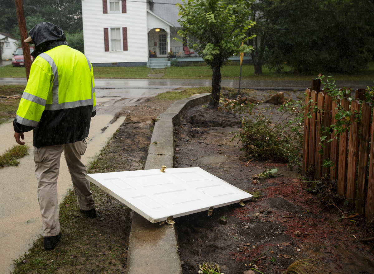 Soddy-Daisy Police Sgt. Mike Brown walks past the door of a home that washed up one day after a deadly flash flood in the Depot Street area on Thursday, Sept. 27, 2018, in Soddy-Daisy, Tenn. Residents, volunteers and business owners returned Thursday following the flooding which killed one person Wednesday.