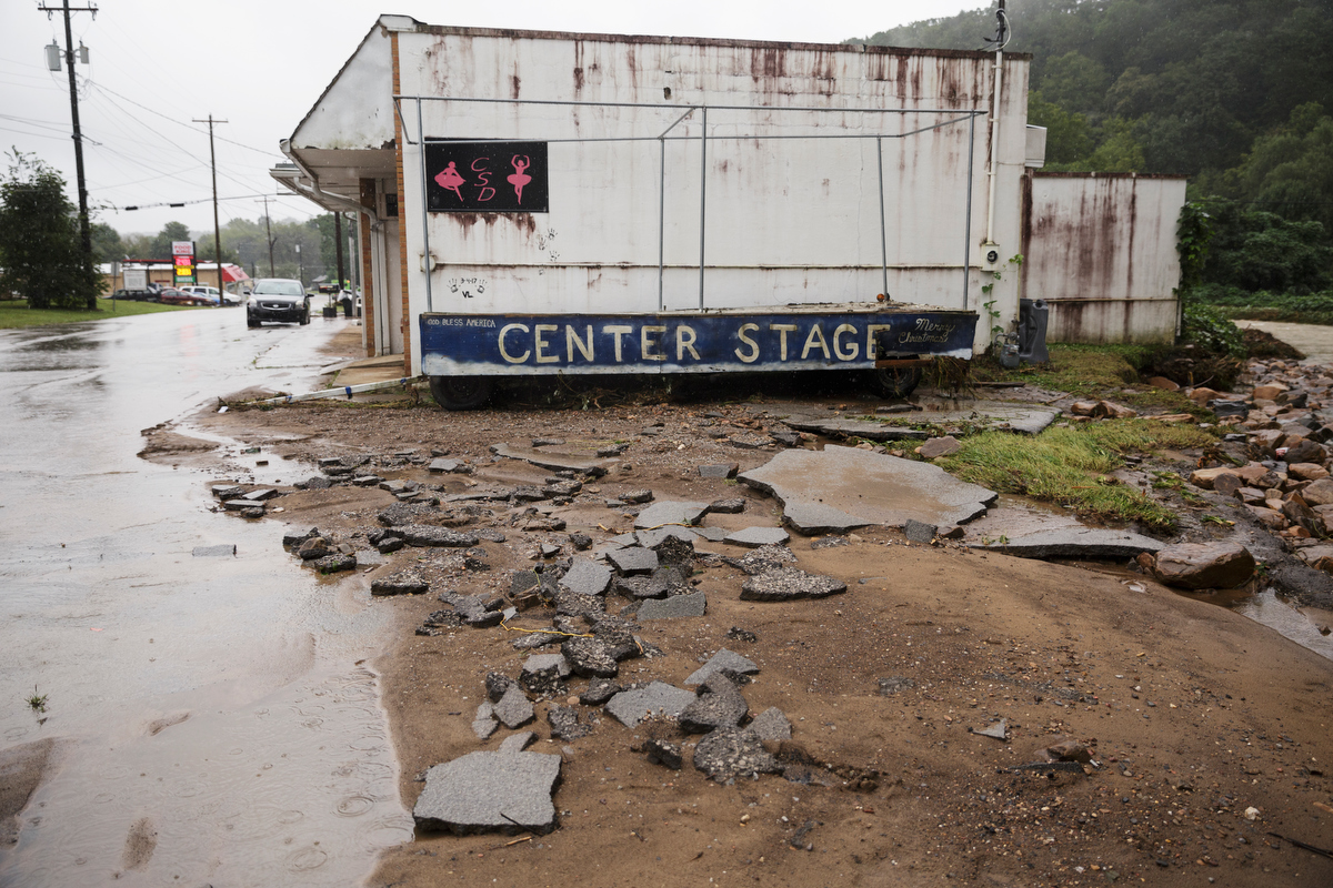 Broken asphalt collects near the Center Stage dance studio one day after a deadly flash flood in the Depot Street area on Thursday, Sept. 27, 2018, in Soddy-Daisy, Tenn. Residents, volunteers and business owners returned Thursday following the flooding which killed one person Wednesday.