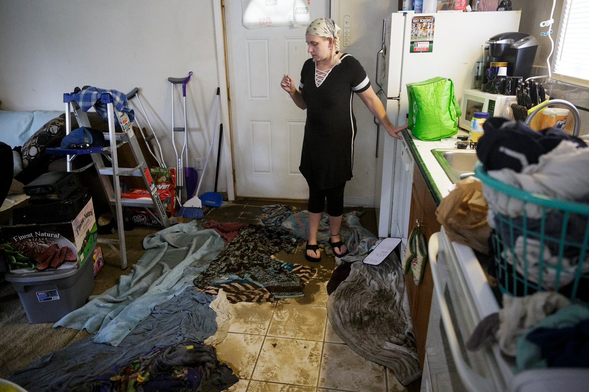 Joni Allen collects food and belongings inside her mother's flooded home one day after a deadly flash flood in the Depot Street area on Thursday, Sept. 27, 2018, in Soddy-Daisy, Tenn. Residents, volunteers and business owners returned Thursday following the flooding which killed one person Wednesday.
