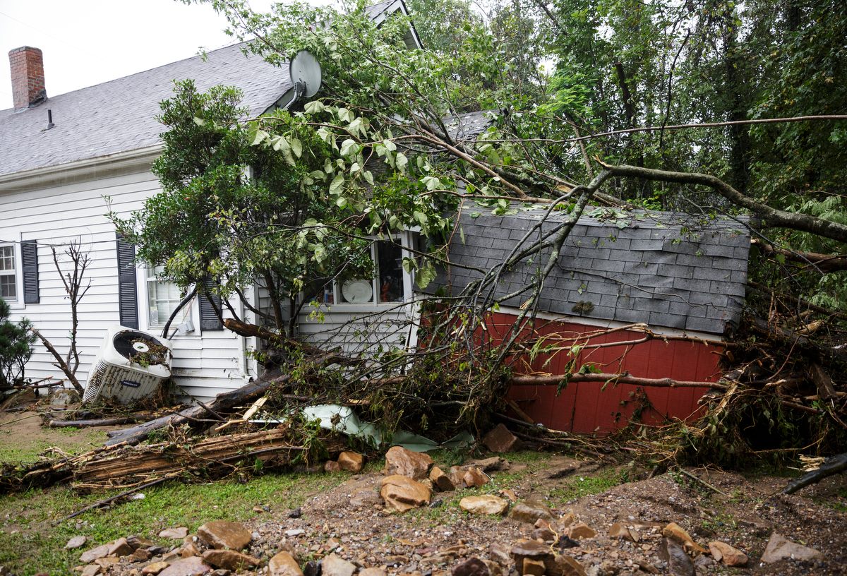 A utility building is smashed into a home one day after a deadly flash flood in the Depot Street area on Thursday, Sept. 27, 2018, in Soddy-Daisy, Tenn. Residents, volunteers and business owners returned Thursday following the flooding which killed one person Wednesday.