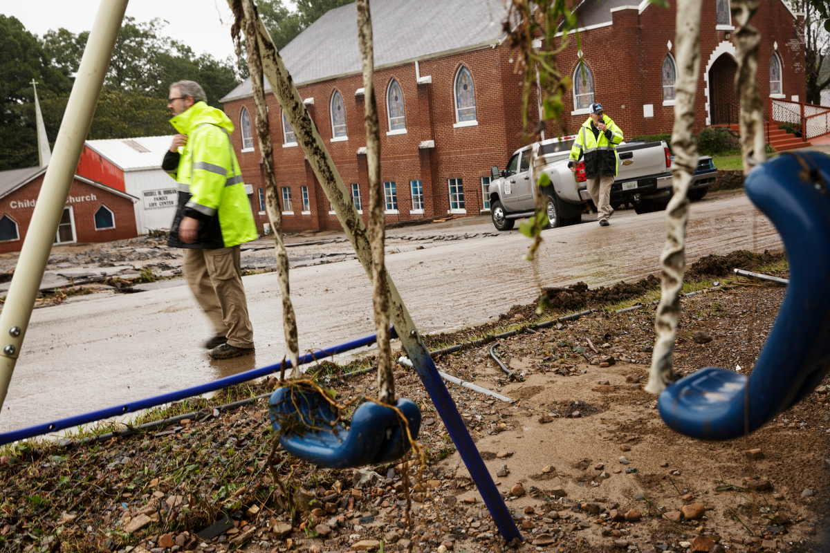 Hamilton County emergency workers Greg Helms, left, and Greg Smith walk near a broken swing set one day after a deadly flash flood in the Depot Street area on Thursday, Sept. 27, 2018, in Soddy-Daisy, Tenn. Residents, volunteers and business owners returned Thursday following the flooding which killed one person Wednesday.