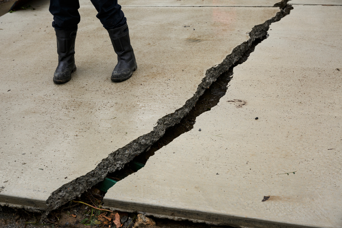 A crack is seen in a driveway one day after a deadly flash flood in the Depot Street area on Thursday, Sept. 27, 2018, in Soddy-Daisy, Tenn. Residents, volunteers and business owners returned Thursday following the flooding which killed one person Wednesday.