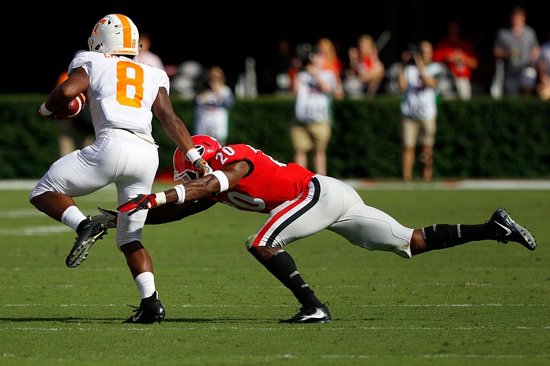 Georgia defensive back J.R. Reed trips up Tennessee running back Ty Chandler during their SEC game on Sept. 29 at Sanford Stadium in Athens, Ga.