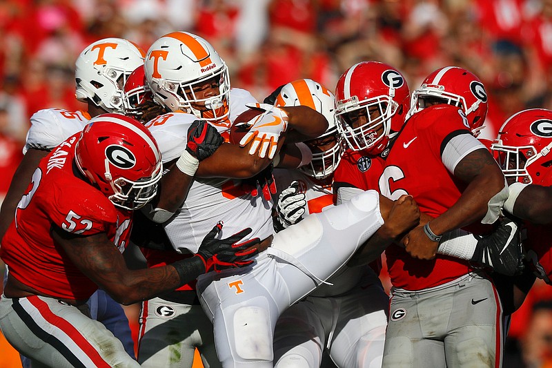 Tyler Clark, left, and Natrez Patrick lead the charge as Georgia's defense stops Tennessee running back Jeremy Banks during an SEC East matchup Saturday afternoon at Sanford Stadium in Athens, Ga. Banks, who finished with 18 yards on six carries, had a late fumble that deflated the Vols' rally in a 38-12 loss.