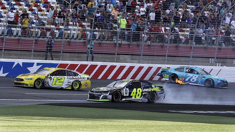 Ryan Blaney (12) drives past the wrecked cars of Jimmie Johnson (48) and Martin Truex Jr. (78) to win Sunday's race on the "roval" layout at Charlotte Motor Speedway in Concord, N.C. Johnson collided with Truex after trying to slip past for the victory.