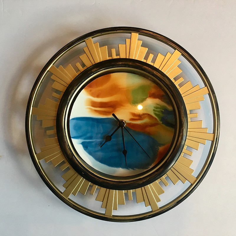 "City Time," above, by Nadine Koski is a plastic rim with alcohol ink painting on yupo. At right is "Quarter Time" by Denice Bizot. The piece combines walnut, steel and paint.