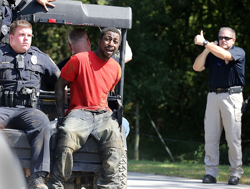 Staff photo by Erin O. Smith / A manhunt suspect is carried on the back of a park ranger vehicle with law enforcement to put him in the back of a patrol car at the entrance of Camp Jordan on Thursday, October 4, 2018 in East Ridge, Tennessee.