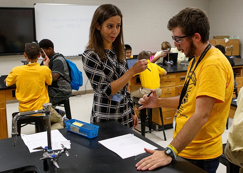 Jill Landtroop, a Hamilton County Department of Education middle and high school new teacher coach, helps Seventh-grade science teacher Owen Bogolin, right, get an experiment set up at Orchard Knob Middle School on Friday, Oct. 5, 2018 in Chattanooga, Tenn.