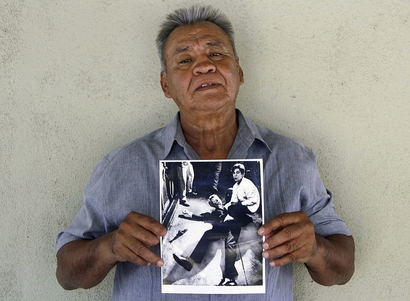 This photo provided by STORYCORPS shows Juan Romero holding a Los Angeles Times photograph that shows Romero with Sen. Robert F. Kennedy at the Ambassador hotel in Los Angeles moments after Kennedy was shot. The Los Angeles Times reported Thursday, Oct. 4, 2018, that Romero died Monday in Modesto, California, at age 68. Romero was a busboy in June 1968 when Kennedy walked through the Ambassador Hotel kitchen after his victory in the California presidential primary and an assassin shot him in the head. He held the mortally wounded Kennedy as he lay on the ground, struggling to keep the senator's bleeding head from hitting the floor. (Jud Esty-Kendall/STORYCORPS via AP)

