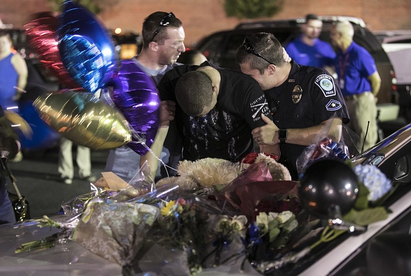 Florence Police officers mourn at a makeshift memorial, Thursday, Oct. 4, 2018, in Florence, S.C., following a candlelight vigil for Sgt. Terrence Carraway who was killed in the line of duty on Wednesday. (Jason Lee/The Sun News via AP)

