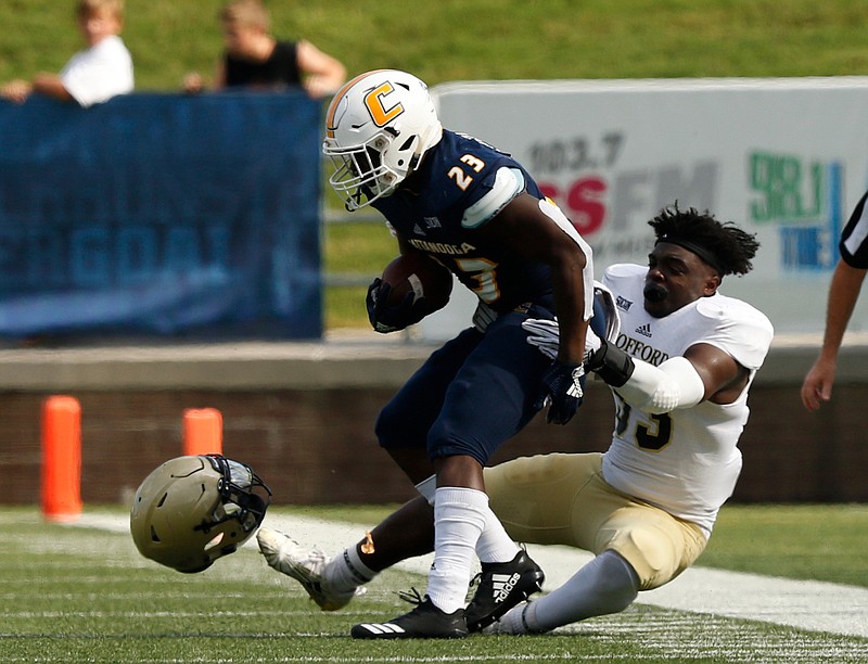 Wofford linebacker Brandon Brown tackles UTC running back Tyrell Price after losing his helmet during Saturday's game at Finley Stadium.
