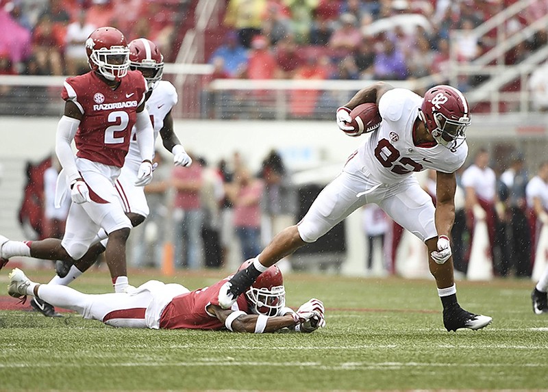 Alabama receiver Gary Cross slips past Arkansas defender Santos Ramirez in the first half of Saturday's SEC matchup in Fayetteville, Ark.