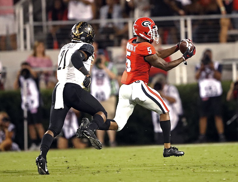 Georgia wide receiver Terry Godwin catches a touchdown pass as Vanderbilt cornerback Donovan Sheffield trails him during Saturday night's game in Athens, Ga.