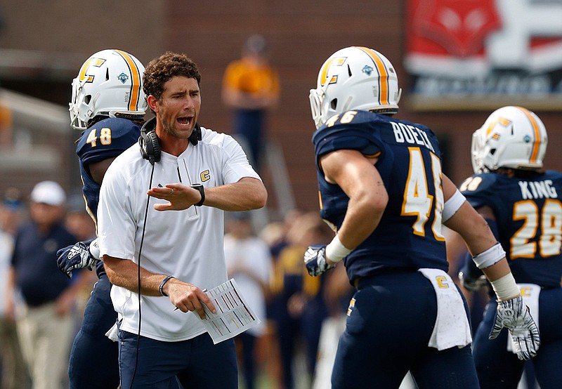 UTC football coach Tom Arth congratulates UTC linebacker Ty Boeck during a home game against Wofford on Oct. 6.