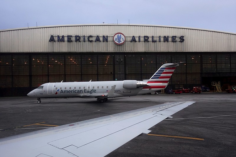 FILE- In this March 12, 2018, file photo, operations proceed outside the American Airlines facility at LaGuardia Airport in New York. A new policy at American Airlines could leave more coach passengers stranded after delays or canceled flights. The airline is telling agents to avoid rebooking economy customers on other airlines, with a few exceptions like people flying to a wedding.  (AP Photo/John Minchillo, File)