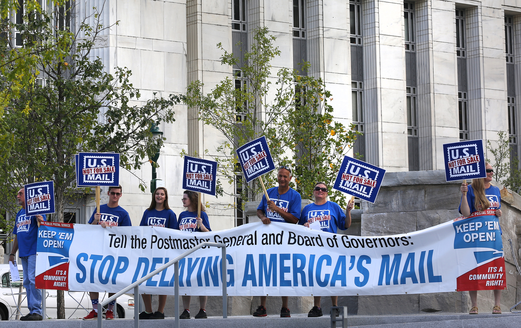 Protestors stand with signs in Miller Park Monday, October 8, 2018 in Chattanooga, Tennessee. The rally was held in opposition to President Donald Trump's plan to privatize the post office.
