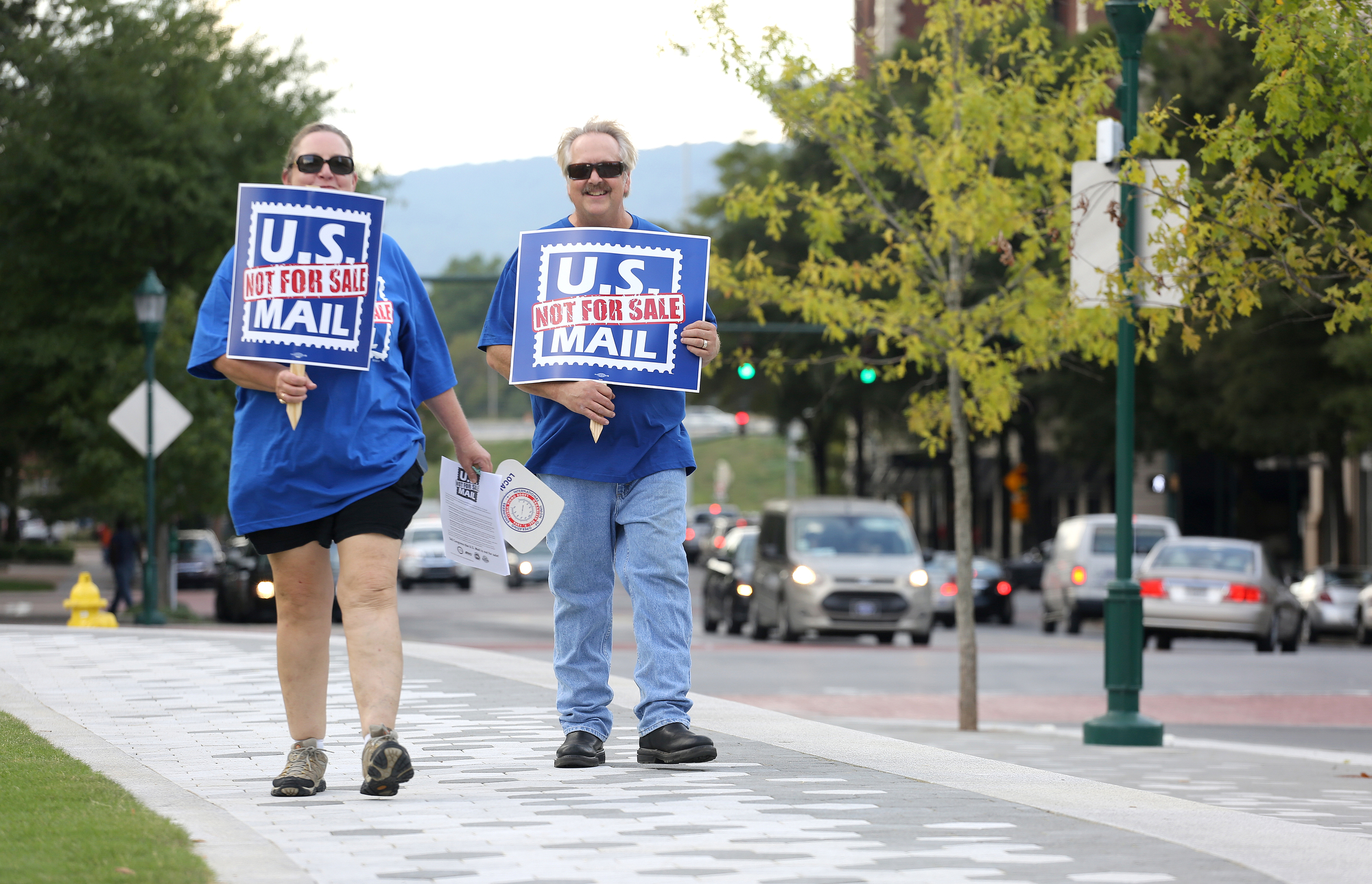 Donna and Terrell Lancaster walk around Miller Park with signs that read "U.S. Mail Not For Sale" in protest of talks of privatization for the postal service Monday, October 8, 2018 at Miller Park in Chattanooga, Tennessee. Donna is a mail carrier for the U.S. Postal Service, and Terrell is a motor vehicle craft director for the U.S. Postal Service.