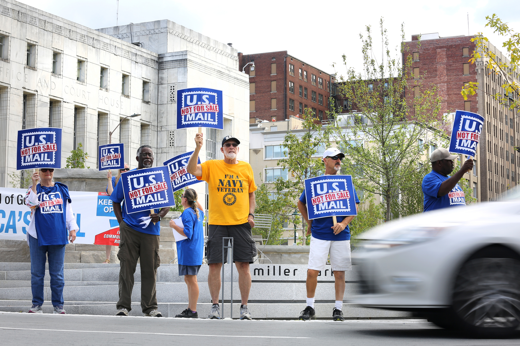 Protestors stand with signs in Miller Park as cars pass by on M.L. King Boulevard Monday, October 8, 2018 in Chattanooga, Tennessee. The rally was held in opposition to President Donald Trump's plan to privatize the post office.