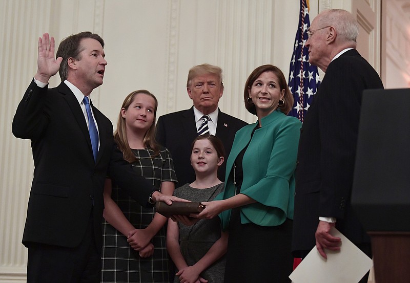 President Donald Trump, center, listens as retired Supreme Court Justice Anthony Kennedy, right, ceremonial swears in Supreme Court Justice Brett Kavanaugh, left, in the East Room of the White House in Washington on Monday. Kavanaugh's wife Ashley watches, second from right. (AP Photo/Susan Walsh)