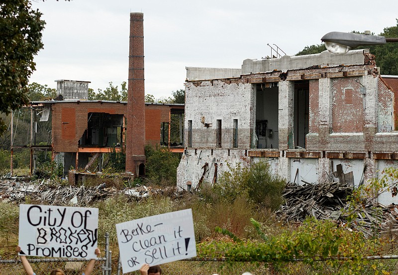 Residents hold up signs during a news conference held by Lupton City residents to voice complaints about delays to clean up the the Lupton Mill site on Wednesday, Oct. 10, 2018, in Chattanooga, Tenn. Residents asked the city to expedite the cleanup, citing pollution, rats and and mosquitoes among their complaints.