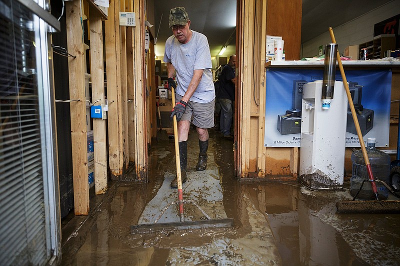 Gatekeepers Inc. owner Marty Kazmier mops mud out of his business one day after a deadly flash flood in the Depot Street area in Soddy-Daisy. Residents, volunteers and business owners returned Sept. 27 following the flooding which killed one person Sept. 26.