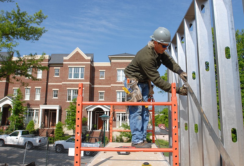 John Smith works on the framing of a townhome in the Walnut Hill Townhomes development at Walnut Street and Aquarium Way.