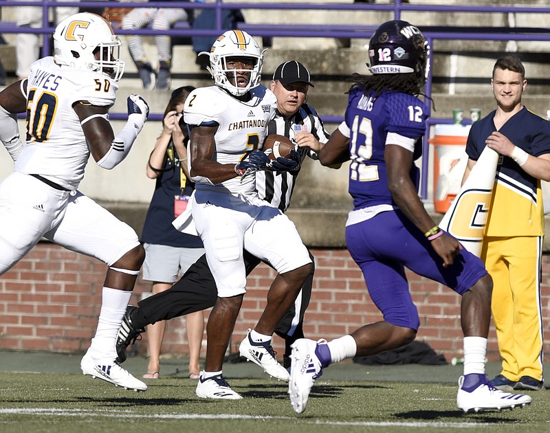UTC defensive back Kareem Orr returns an interception as teammate Ian Hayes, left, comes up to block Western Carolina quarterback Tyrie Adams during their Southern Conference matchup Oct. 13 in Cullowhee, N.C.