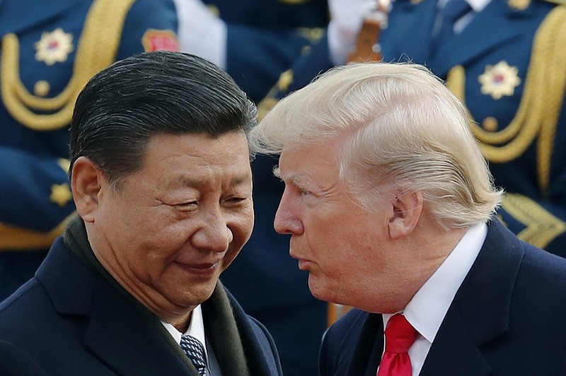 FILE - In this Nov. 9, 2017, file photo, U.S. President Donald Trump, right, chats with Chinese President Xi Jinping during a welcome ceremony at the Great Hall of the People in Beijing. China said Friday, Oct. 12, 2018 it is in contact with the United States amid reports of a planned meeting between President Xi Jinping and President Donald Trump next month following a dive in the U.S. stock market blamed partly on a growing trade war between the world's two largest economies. (AP Photo/Andy Wong, File)

